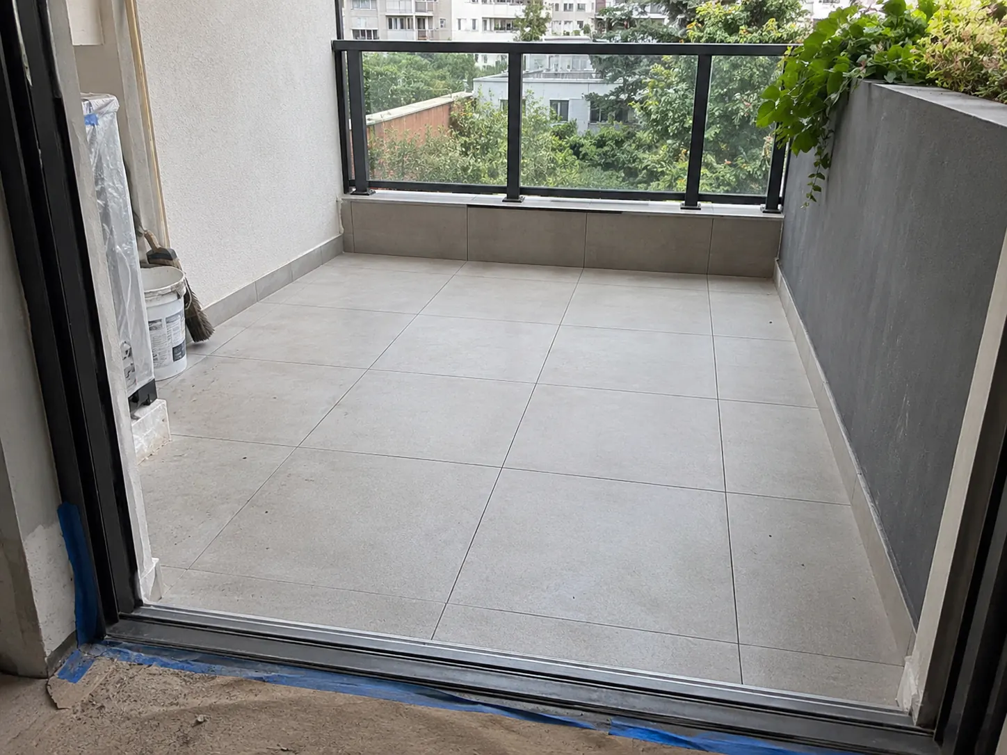 Tiled balcony floor beside a glass balustrade