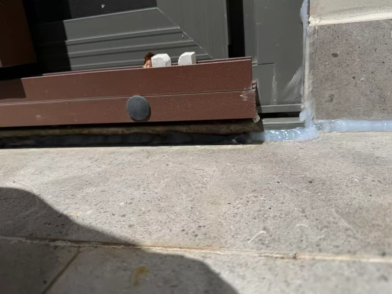 Sealed exterior wall and doorway junction at a concrete threshold