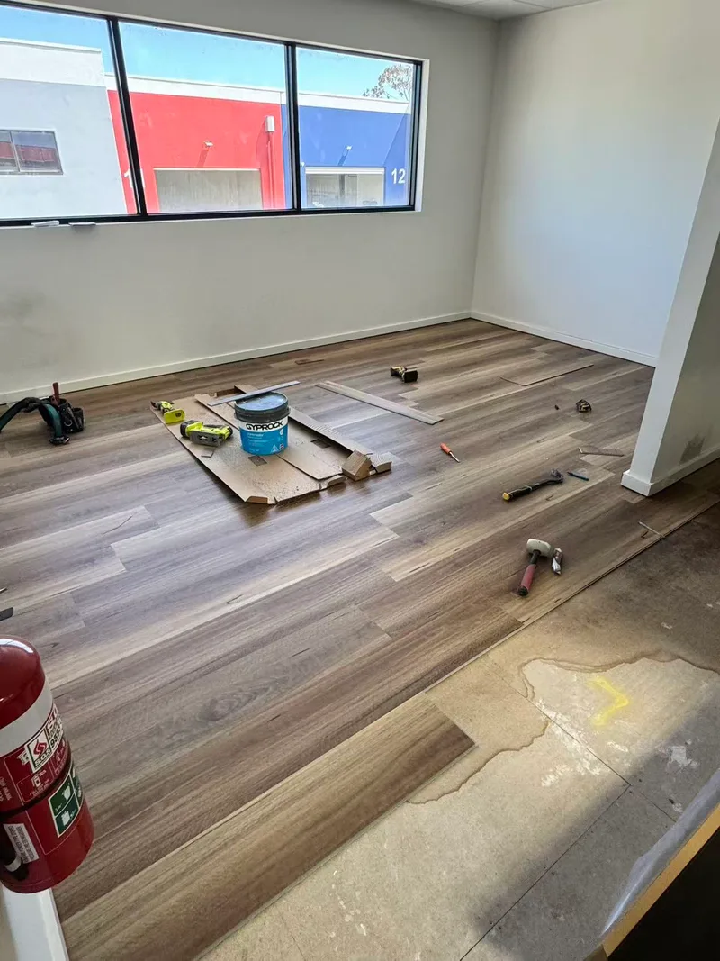 Timber boards partly installed with tools on the floor